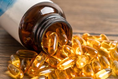 Balık yağı Omega 3 kapsülleri EPA ve DHA vitaminleri ahşap arka planda izole edilmiş..