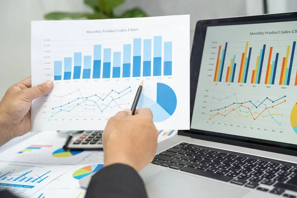 Modern ofis, finans ve iş konseptinde grafik grafik grafiği ve hesap makinesiyle çalışan ve finansal raporları analiz eden Asyalı muhasebeci.