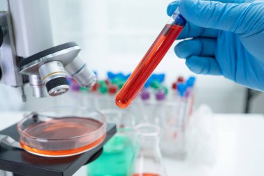 Laboratuvarda mikroskopla çalışan Asyalı biyokimyacı ya da mikrobiyolog. Coronavirus salgınını korumak için. Covid19, bakteri ve mikroplar..