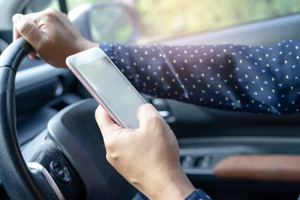 Holding mobile phone in car to communication with family and friends.