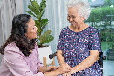 Tekerlekli sandalyede oturan ve güvenlik enfeksiyonu Covid 19 Coronavirus 'u korumak için maske takan yaşlı yaşlı kadına yardım edin..