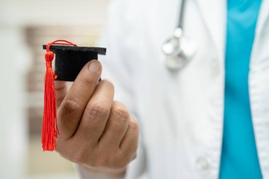 Asyalı doktor eğitimi, hastane koğuşunda mezuniyet şapkasıyla, zeki dahi tıp konseptiyle öğreniyor..