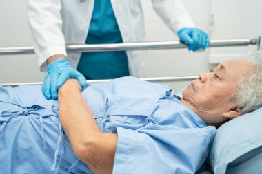 Asyalı yaşlı ya da yaşlı kadın hasta ile el ele tutuşmak. Sevgi, ilgi, cesaret ve empati, hemşire hastanesi koğuşunda sağlıklı ve güçlü tıbbi konsept.