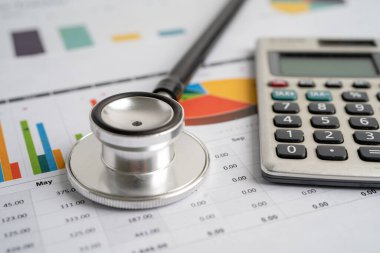 Grafik kağıdı, finans, hesap, istatistik, analitik ekonomi iş kavramı üzerinde hesap makinesi ile stetoskop.