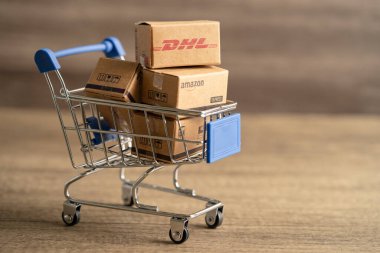 Bangkok, Tayland - 26 Eylül 2022 DHL Amazon ekspres paketleme kutusu ile alışveriş arabası, çevrimiçi döviz alım-satımı işi.