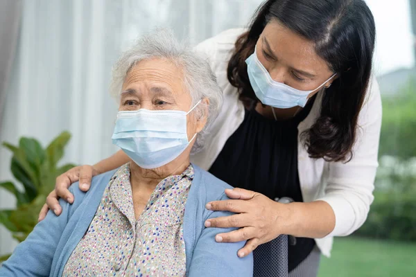 Help Asian senior or elderly old lady woman sitting on wheelchair and wearing a face mask for protect safety infection Covid19 Coronavirus.