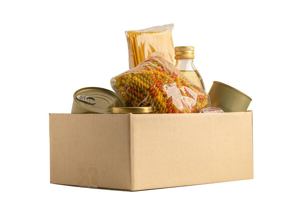 Продукты для пожертвования, хранения и доставки. Различные продукты питания, макароны, растительное масло и консервы в картонной коробке.