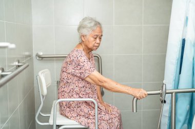 Asyalı yaşlı yaşlı kadın hasta, hemşire hastanesi koğuşunda tuvalet temizliği yapıyor. Sağlıklı güçlü tıbbi konsept..