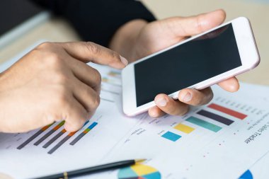 Modern ofis, finans ve iş konseptinde grafik grafik grafiği ve hesap makinesiyle çalışan ve finansal raporları analiz eden Asyalı muhasebeci.