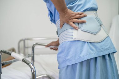 Ortopedik bel kemiği için sırt ağrısı destek kemeri takan Asyalı bir hasta..