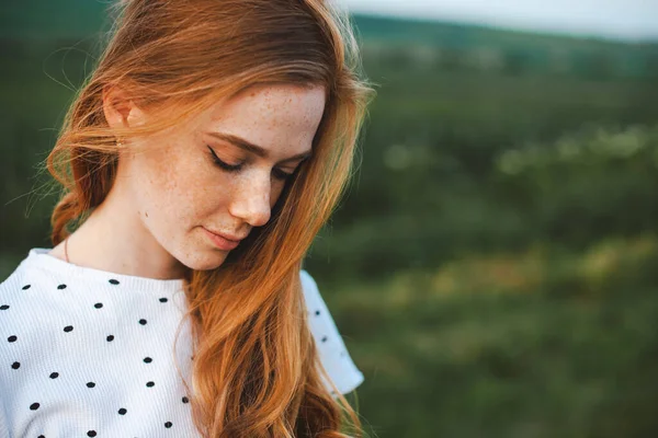 Mujer de jengibre en el campo posando cerca para un diseño de estilo de vida saludable. Cabello sano. Cara de belleza. Persona positiva. — Foto de Stock