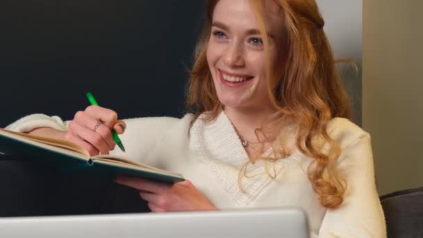 ビデオだ。ノートに書いてある赤い髪の女性の肖像画は快適に立っています。楽しい学習だ。オンライン教育。接続された人々. — ストック動画