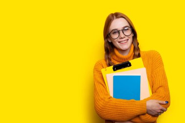 İki örülmüş boyunlu, gözlüklü, çilli bir kadın elinde çarşaf ve defterle okulu düşünürken yüzünü çeviriyor. Sarı arkaplanda boş alan