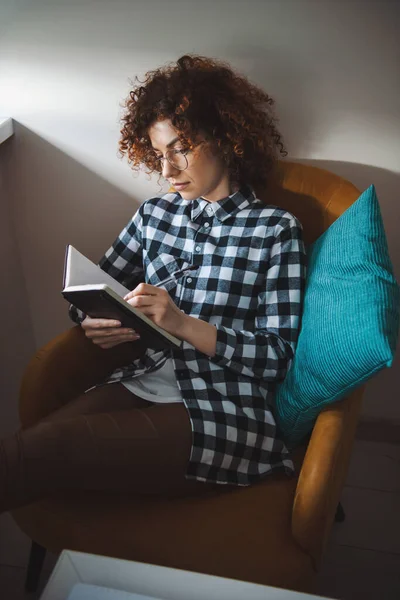 Mujer pasando su tiempo libre planeando su agenda. No hay conexión a Internet. Cabello rizado. — Foto de Stock