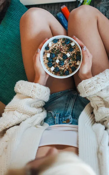 Jeune femme tenant dans ses mains un bol de céréales. Petit déjeuner bio sain — Photo