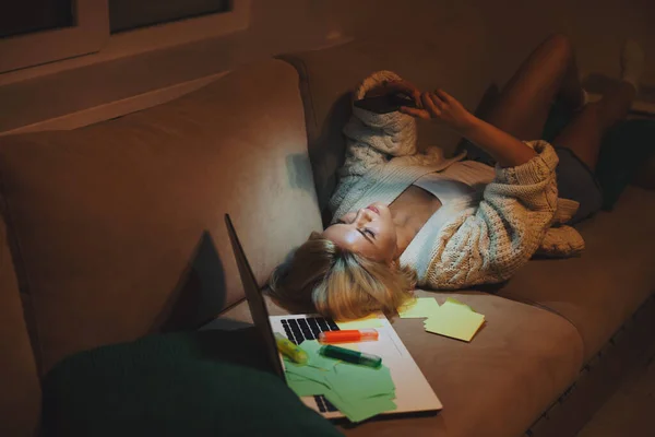Mujer acostada en un sofá. Estudio en línea. Estudiante estudiando en casa — Foto de Stock