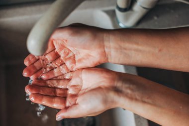 Kadın elinin portresini kapat ellerini lavabonun musluk suyunun altında yıka. Coronavirus. Salgın durumu.