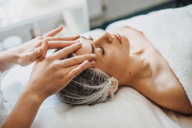 Kaplıca salonunda yüz bakımı gören bir kadının yakın plan portresi. Yüz bakımı. Yenilenme tedavisi.