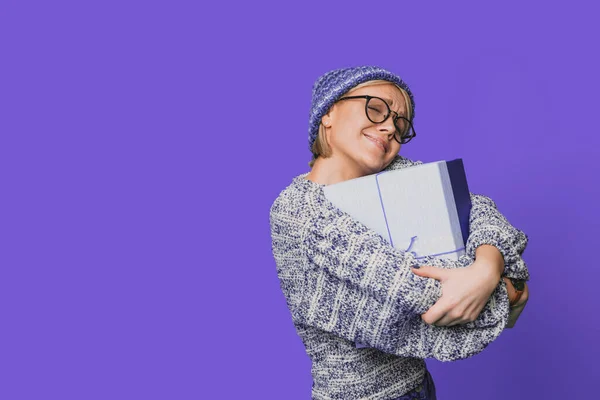 Retrato de una mujer caucásica disfrutando del regalo de su novio con gafas aisladas sobre fondo de color púrpura. Tiempo de Navidad. —  Fotos de Stock