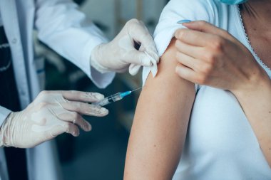 Hasta kolunda aşı yapan bir doktorun portresini yakından çekelim. Grip aşısı. Coronavirus. Covid-19 aşısı.