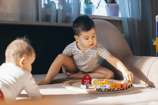 Irmãos brincando com ferrovia de madeira. Menino. Brinquedo colorido. Infância — Fotografia de Stock