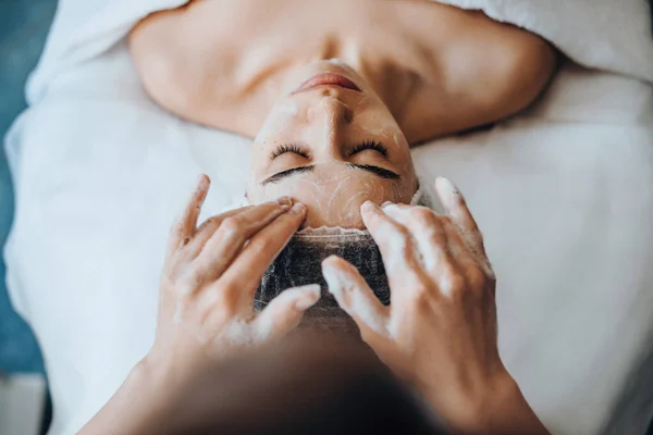 Retrato de close-up de esteticistas mãos aplicando espuma de limpeza facial. Dermatologia, cosmetologia. — Fotografia de Stock