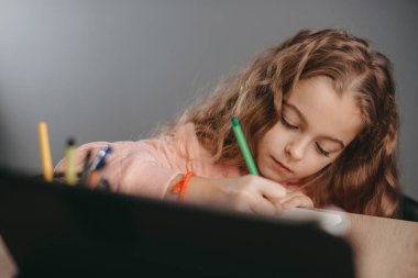 Öğrenmek için aletler kullanan beyaz bir öğrencinin yakın plan portresi. İnternette okuyan bir kız. Uzaktan eğitim. Coronavirüs.