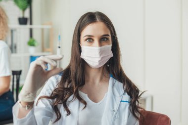 Bir hemşirenin portresi. Doktorun elinde aşı olan bir şırınga. Corona virüsü aşılama. Nüfusun aşılanması. Covid 19