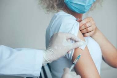 Hastaya iğne yapmadan önce elinde şırınga tutan ve pamuk kullanan doktorların yakın plan portresi. Profesyonel tıbbi konsept. Kapak aşısı kavramı
