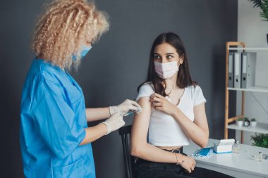 Kafkasyalı bir kadın için aşı bulan bir doktor. Kapak aşısı konsepti. Karantina yaşam tarzı. Enjeksiyon covid aşı konsepti. Tıbbi tedavi.