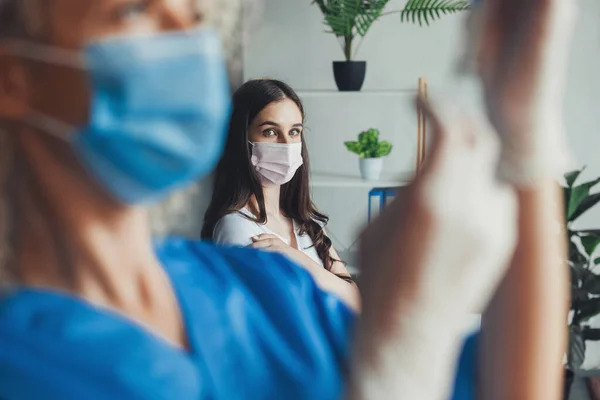 Perawat mengenakan masker wajah dan memegang jarum suntik vaksin covid-19 di rumah sakit. Imunisasi virus Corona. — Stok Foto