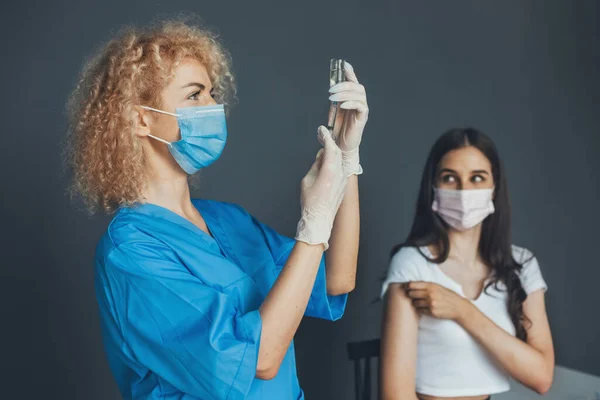 Pielęgniarka przygotowuje się do wstrzyknięcia szczepionki przeciw koronawirusowi. Uodpornianie wirusa korony. — Zdjęcie stockowe