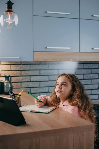 Niña caucásica estudiando deberes durante su lección en línea en casa con la tableta. Cuarentena. Autoaislamiento. Concepto de educación online. Covid-19. —  Fotos de Stock