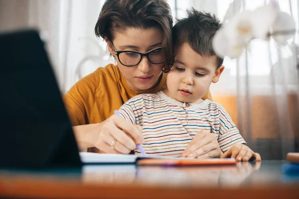 Mom teaching with love his son writing. Family time. — 图库照片