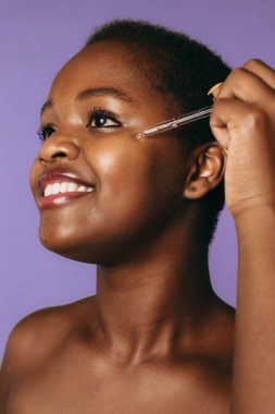 Afrika kökenli Amerikalı bir kadın banyodan sonra kendini şımartıyor. Yakından bir portre. Kozmetik güzellik prosedürü. Sağlık hizmetleri. Spa vücut bakımı