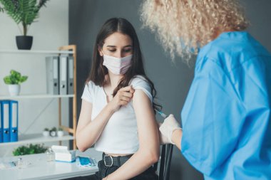 Kadın aşı kampanyası sırasında hastane merkezinde antiviral aşı oluyor. Kadın aşı oluyor. Tıbbi ekipman.