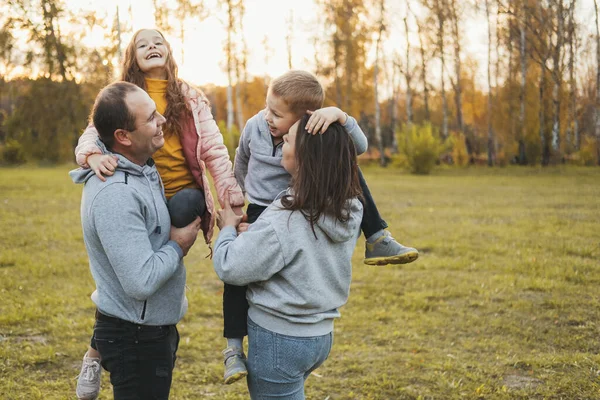 Des parents heureux avec des enfants jouant dans le parc. J'aime ta famille. Quatre membres. — Photo