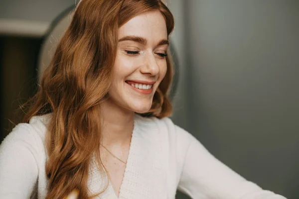 Close-up portrait of a redhead woman sitting at table looking down. Closeup portrait. Healthy young girl. Beautiful girl. Fashion model. — Stockfoto