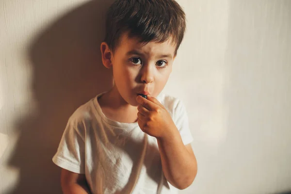 Retrato de cerca de un niño mirando a la cámara mientras come arándanos. Comida dulce. Alimento saludable. —  Fotos de Stock