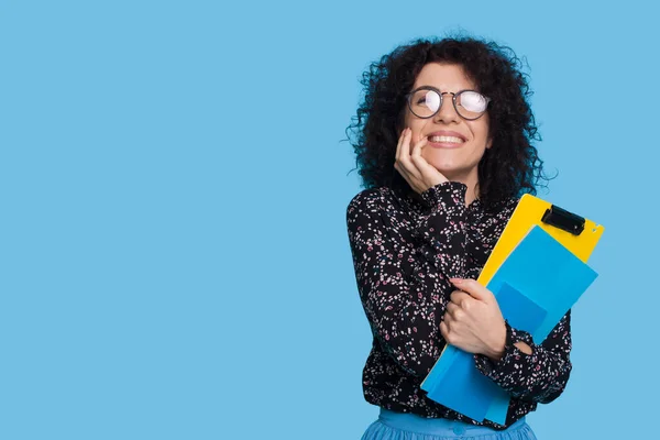 Caucasian student in casual clothes holding books isolated over blue background studio portrait with copyspace. — Zdjęcie stockowe