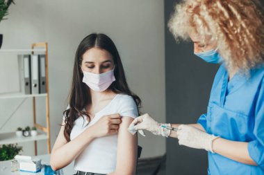 Medical nurse is making a vaccine injection to a patient in a health clinic. Medical treatment. Coronavirus vaccination. Doctor hand.