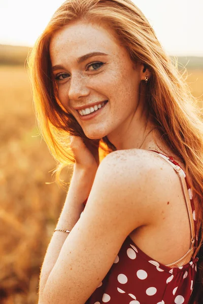 Portrait d'une femme avec des taches de rousseur dans le champ de blé regardant la caméra et souriant. Des gens heureux. Modèle de mode beauté. Paysage naturel. Champ de blé. — Photo