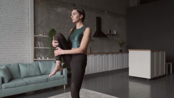 Caucasian woman standing doing the supine wind release posture. Beautiful for lifestyle design. Healthy lifestyle, sport. Yoga body posture. — Stockvideo