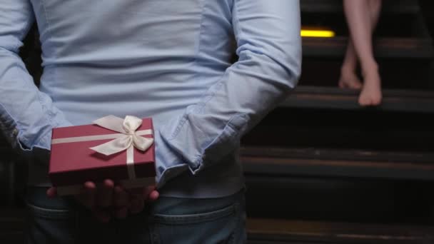 Caucasian man is hiding a present at his back and giving it to his lover on valentines day — Αρχείο Βίντεο