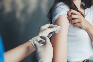 Avrupa Aşılama Kampanyası 'nda kadın koluna uygulanan kovid aşının yakın plan portresi. Antiviral enjeksiyon. Corona virüsü aşılama