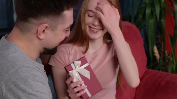 Caucasian man is giving his girlfriend a gift box. Christmas surprise present. Birthday, christmas, valentine. Xmas portrait. — Stock video