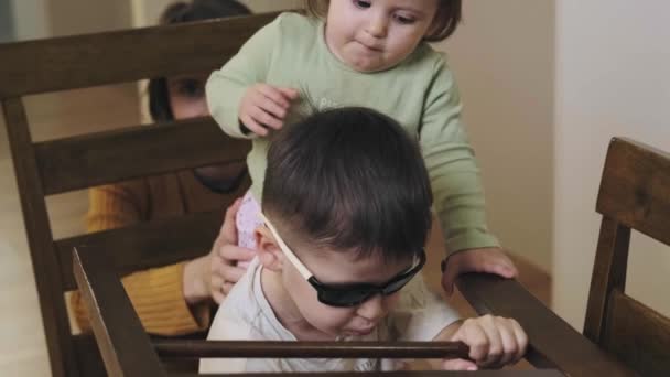 Boy is riding his baby sister in a chair as it is a car. Brother sister imagination car. Quarantine lifestyle. — Video Stock