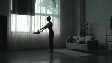 Video with a sportswoman unrolling fitness mat indoors. Profile view. Quarantine lifestyle. Health lifestyle, fitness.