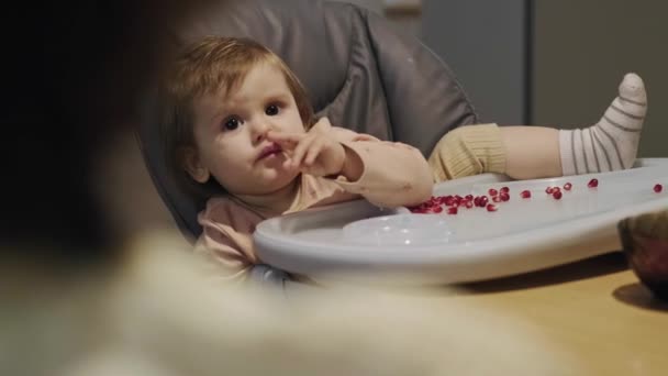 Video with baby had dug into his nose sitting relaxed at the baby table full of grapefruit seeds. Vegetarian food. Healthy food. Organic food. — Stok video