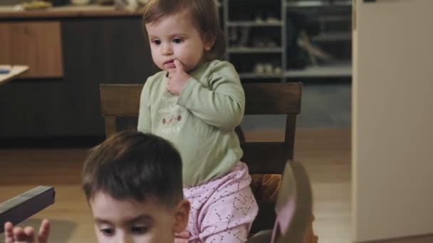 Сім'я грає на кухні, мати тримає дитину, що стоїть на стільці. Карантинний спосіб життя. Здоровий спосіб життя . — стокове відео
